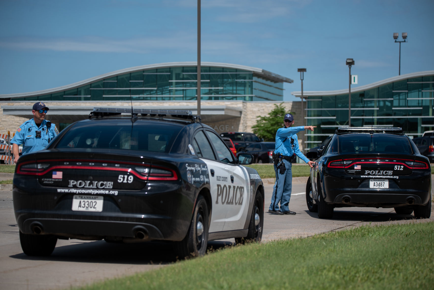 RCPD Officer Brian Jolley, right, points while talking to Sgt. Pat Tiede outside of Manhattan Regional Airport in response to a bomb threat on Friday afternoon.